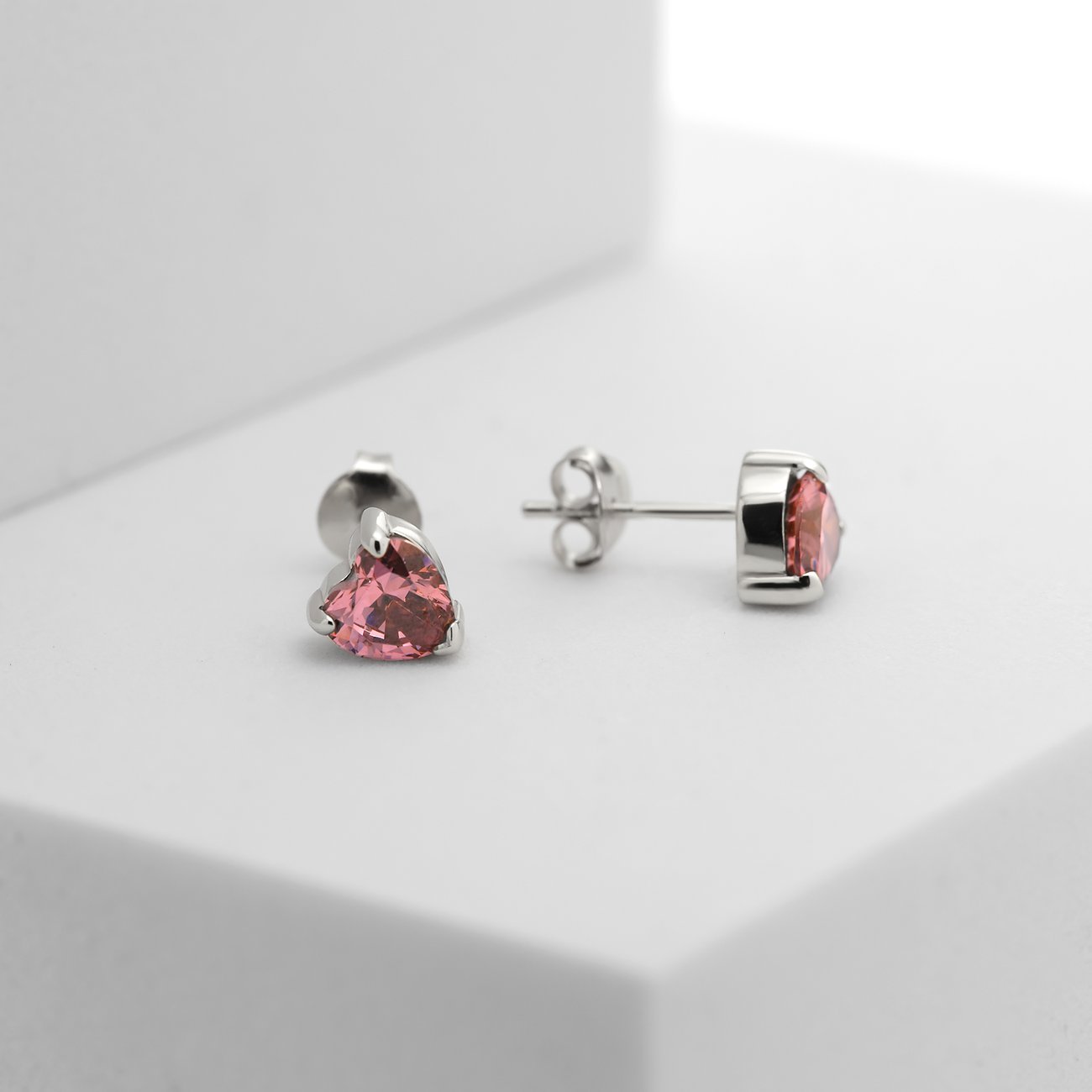 CHRIST Ohrstecker aus recyceltem 925er Silber mit herzförmigen, rosafarbenen Zirkonia Farbsteinen.