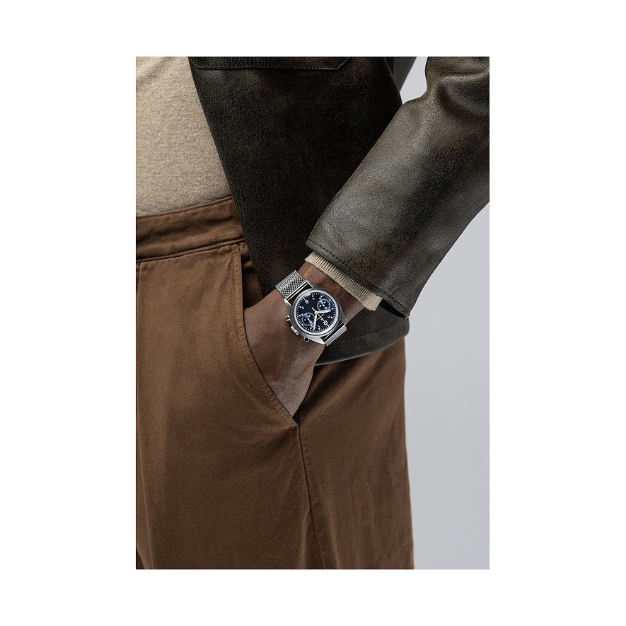 Am Handgelenk eines Mannes, dessen Hand in der Tasche steckt, ist eine Hamilton Herrenuhr aus Edelstahl zu sehen.