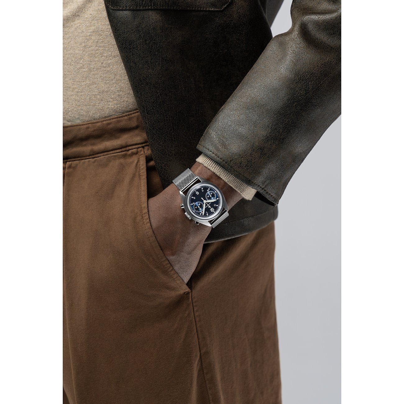 Am Handgelenk eines Mannes, dessen Hand in der Tasche steckt, ist eine Hamilton Herrenuhr aus Edelstahl zu sehen.