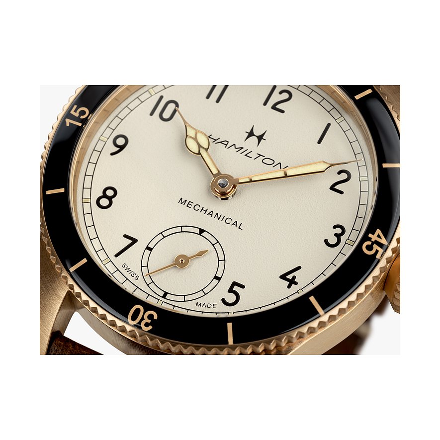 Nahaufnahme einer Hamilton Herrenuhr aus Bronze mit beigem Zifferblatt und schwarzer Lünette, die 