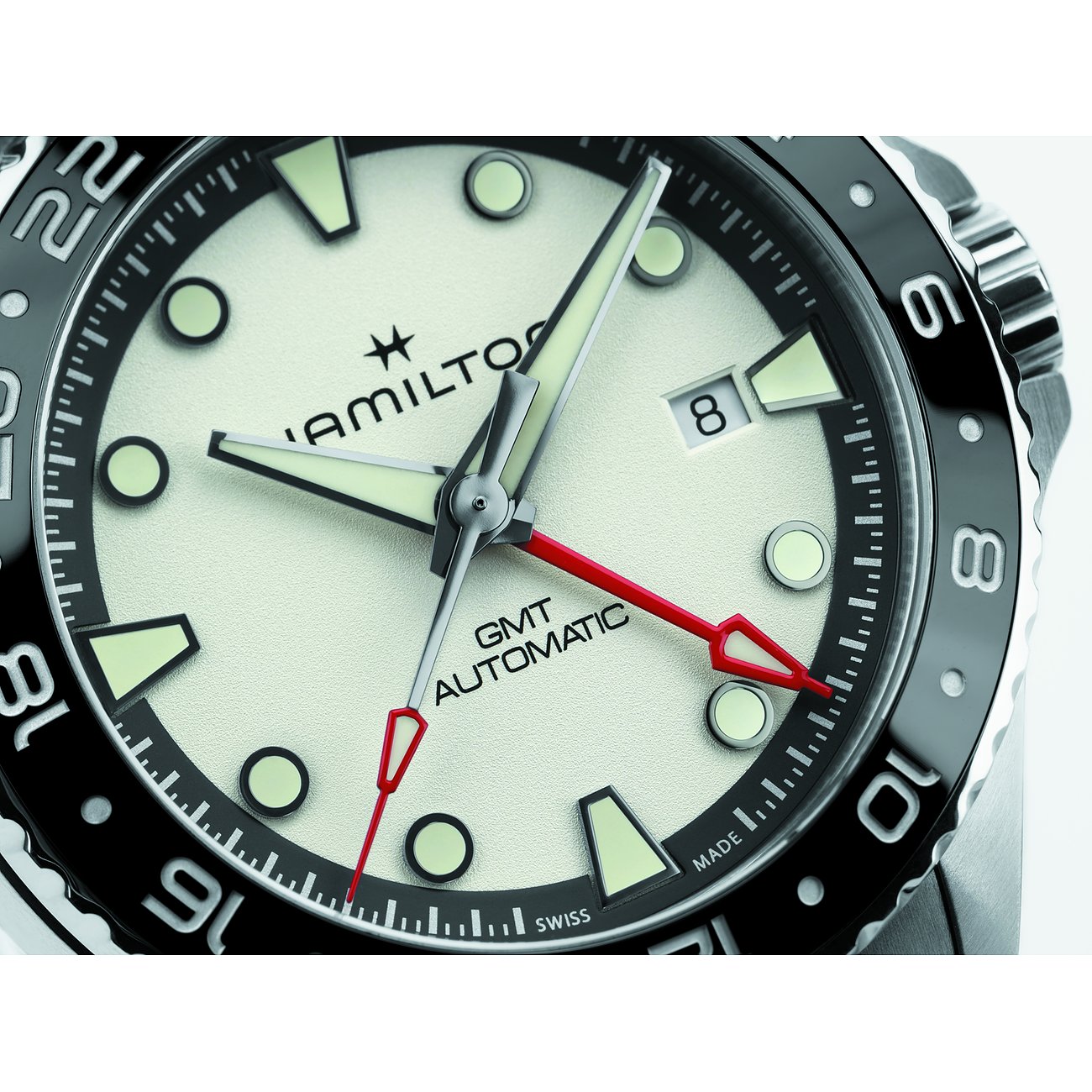 Hamilton Herrenuhr mit Edelstahlgehäuse, cremefarbenem Zifferblatt und schwarzer Lünette.