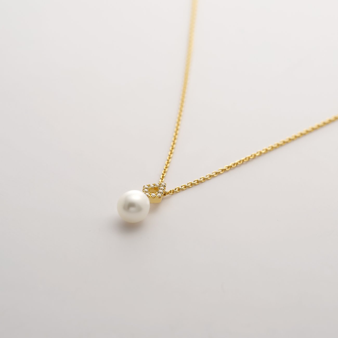 CHRIST CHRIST collier van 375 geelgoud met parel en fonkelende edelstenen aan een filigrane ketting.