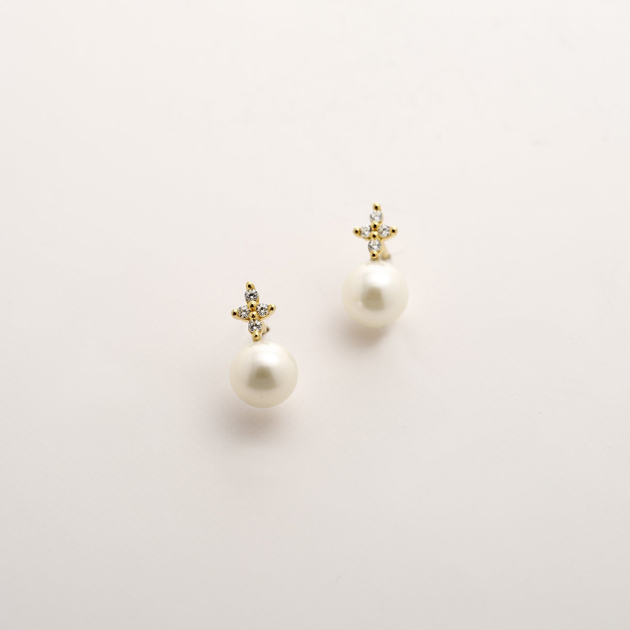 CHRIST Ohrschmuck aus 375er Gelbgold mit Perle und klaren Schmucksteinen in Sternform.