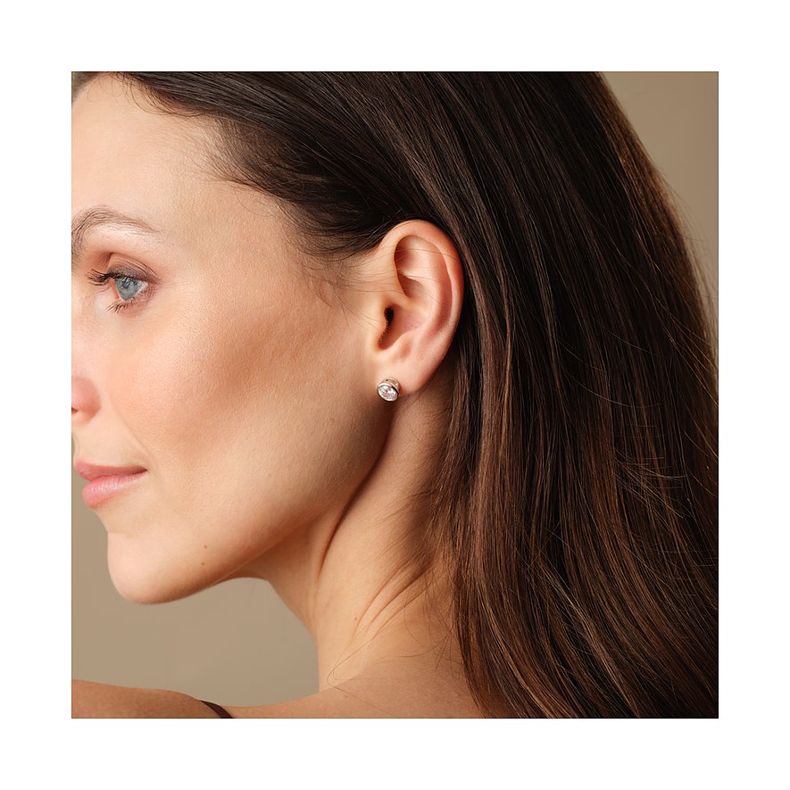 FAVS örhängen i silver m. zirkonia-färgsten, i sidovy på en modells öra.