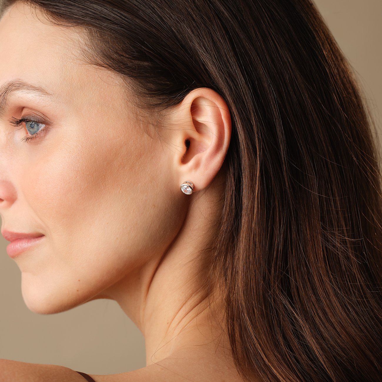 FAVS örhängen i silver m. zirkonia-färgsten, i sidovy på en modells öra.