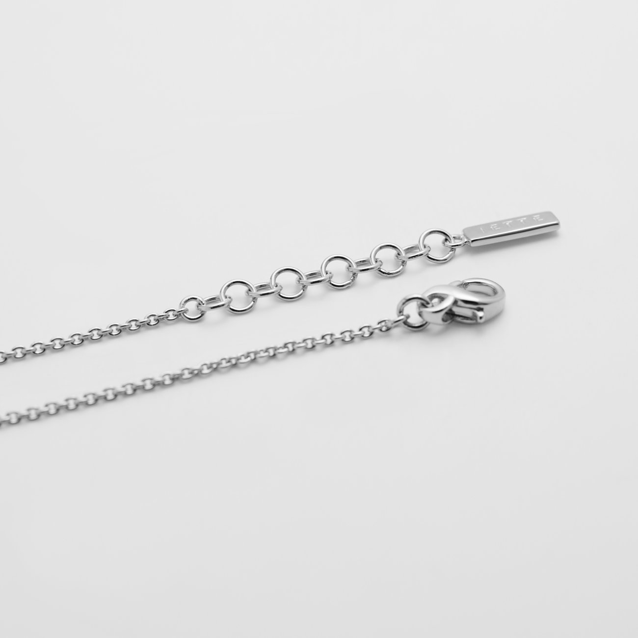 Gros plan du fermoir d'un bracelet JETTE en argent 925 recyclé avec fermoir mousqueton et chaîne d'extension.