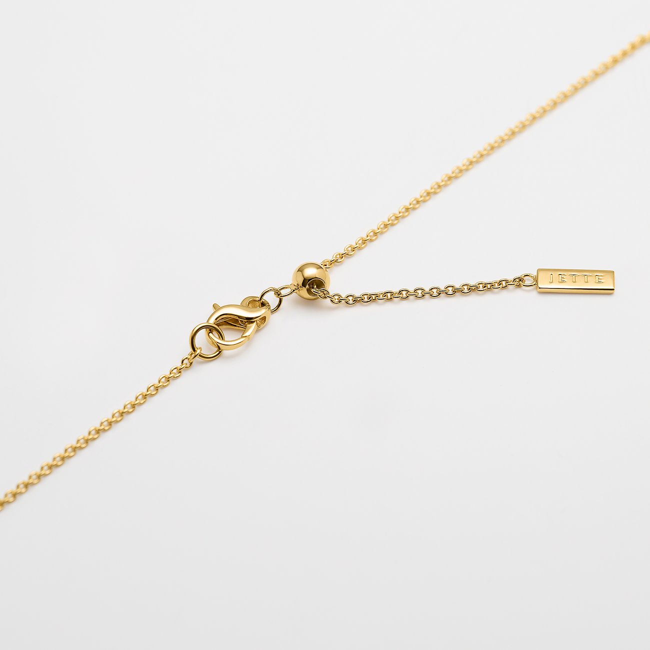 Nahaufnahme des Verschlusses einer goldfarbenen JETTE Halskette aus recyceltem Silber mit verstellbarer Länge.