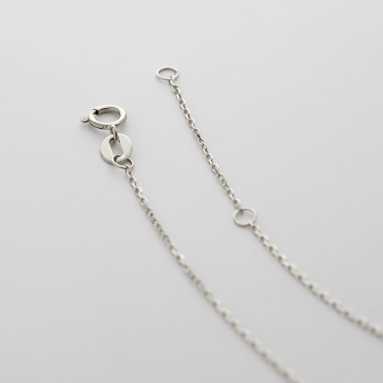 Närbild av låset och förlängningskedjan på ett halsband i vitguld från CHRIST.