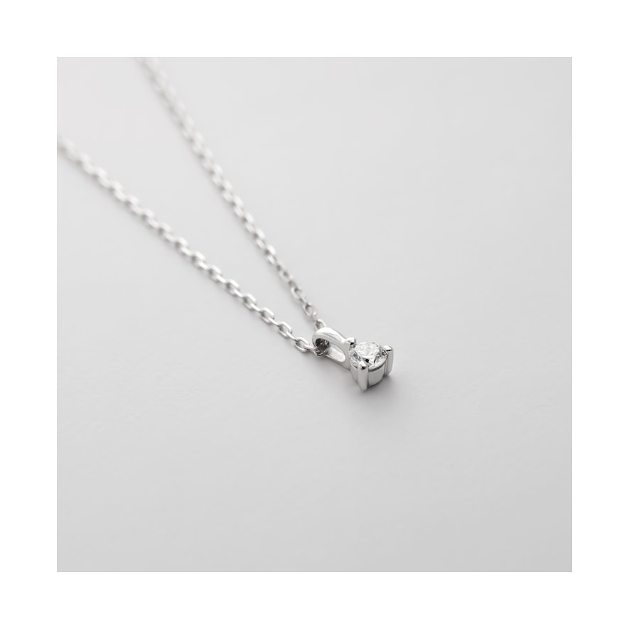 Nahaufnahme einer CHRIST Halskette aus 585 Weißgold mit einem dezenten Diamant-Anhänger auf einer weißen Fläche.
