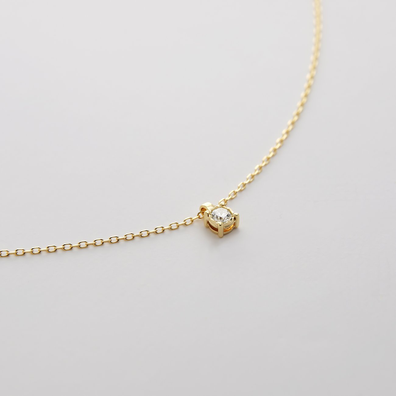 CHRIST Halsschmuck aus Gelbgold: Eine zarte Gelbgoldkette mit einem funkelnden Diamant-Anhänger in vier Krappen.