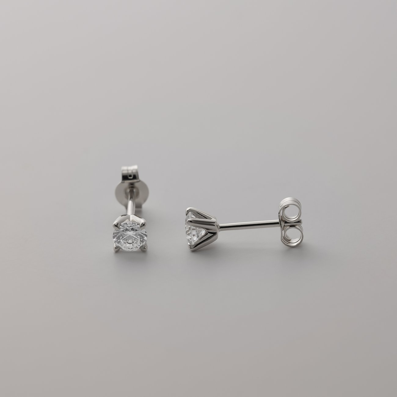 CHRIST Ohrstecker aus 585er Weißgold mit funkelnden Diamanten, der eine liegt auf der Seite und der andere steht.