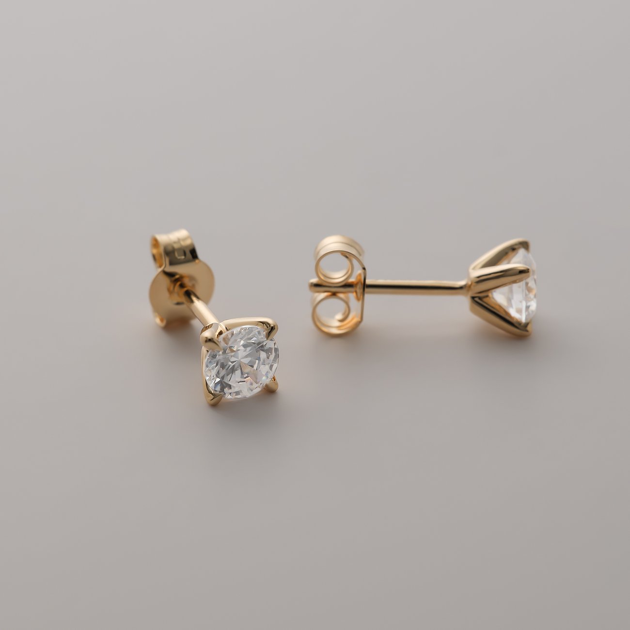 CHRIST Ohrstecker aus Gelbgold mit zwei Diamanten aus der Seitenansicht und von vorne.