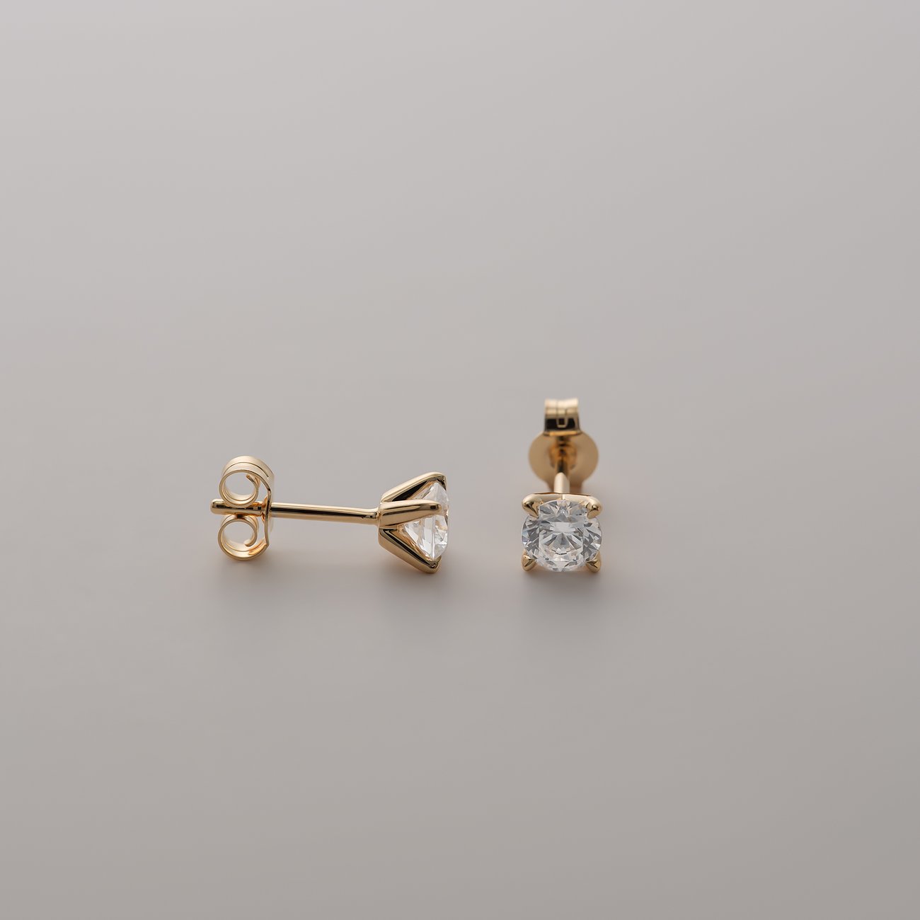 CHRIST 585er Gelbgold Ohrstecker mit funkelnden runden Diamant Steinen, einer frontal und der andere seitlich liegend.