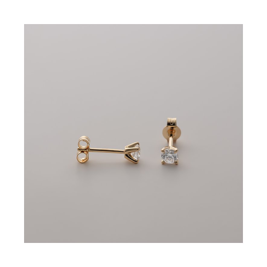 CHRIST Ohrstecker aus 585er Gelbgold mit funkelnden eingefassten Diamanten liegen auf einem hellen Untergrund.