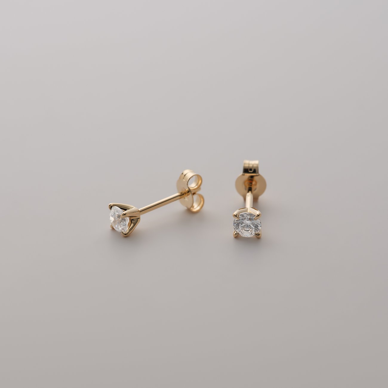 Ein Paar CHRIST Ohrstecker aus 585er Gelbgold mit funkelnden Diamanten, schräg von oben aufgenommen.