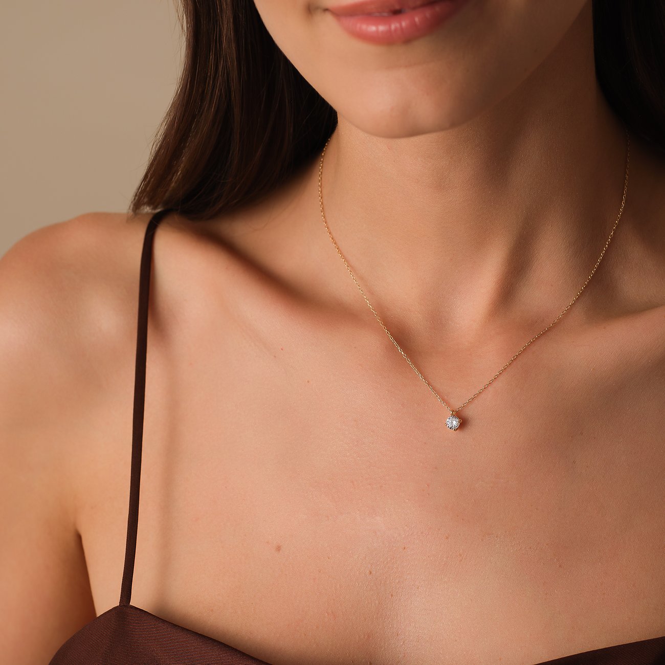 Nahaufnahme eines CHRIST Gelbgold 585 Halsschmucks mit einem runden Diamanten, der an einer zarten Kette hängt.