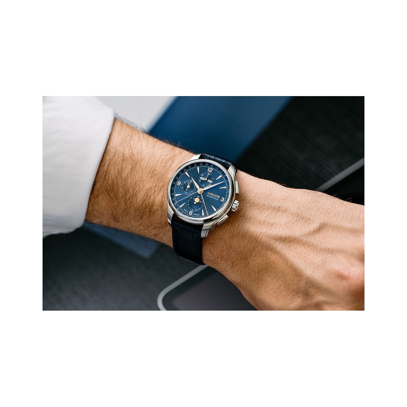 Am Handgelenk eines Mannes wird eine Union Glashütte Herrenuhr aus Edelstahl mit blauem Zifferblatt gezeigt.