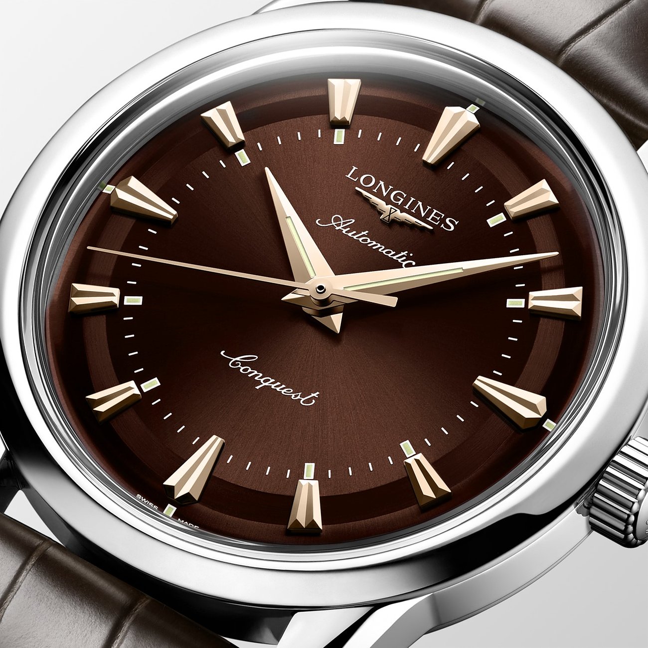 Longines Herrenuhr: braunes Zifferblatt, silbernes Edelstahlgehäuse, goldene Indizes und Zeiger. Nahaufnahme.
