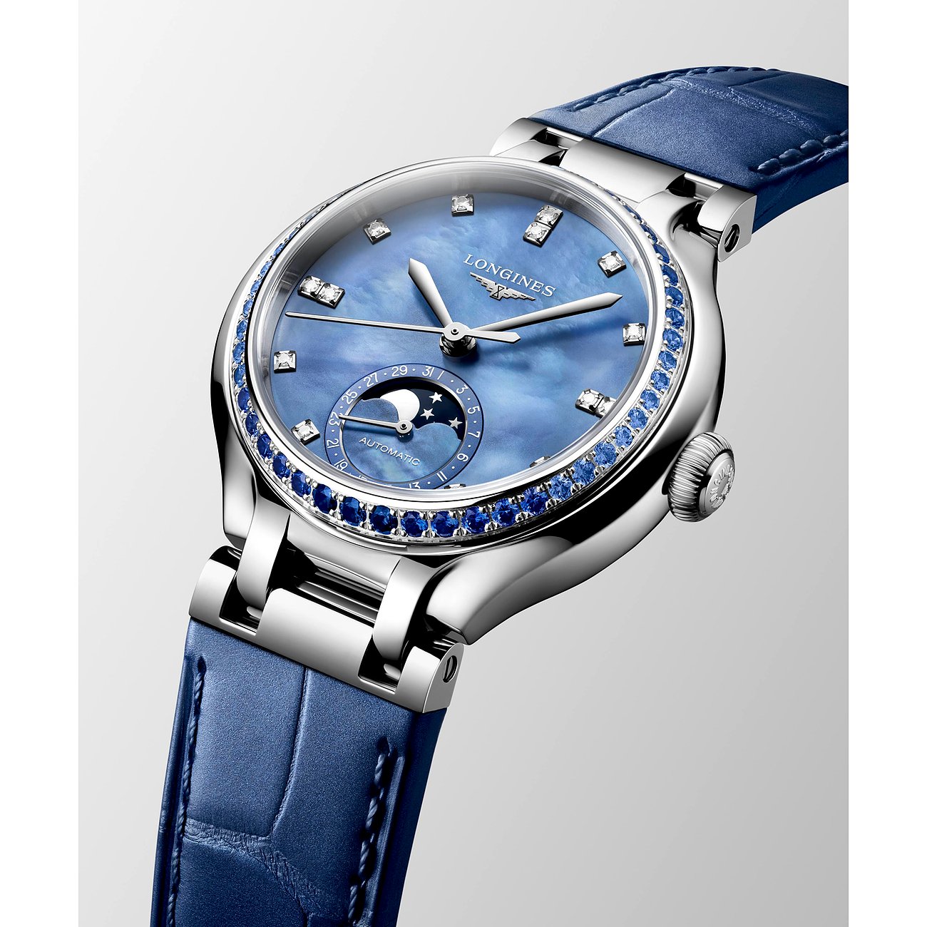 Nahaufnahme einer Longines Damenuhr aus Edelstahl mit blauem Perlmuttzifferblatt, Diamanten und blauen Saphiren.