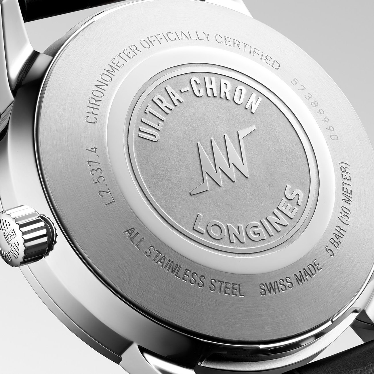 Nahaufnahme der Edelstahl-Rückseite einer Longines Unisexuhr, graviert mit „Ultra-Chron“ und „Longines“ Logo.
