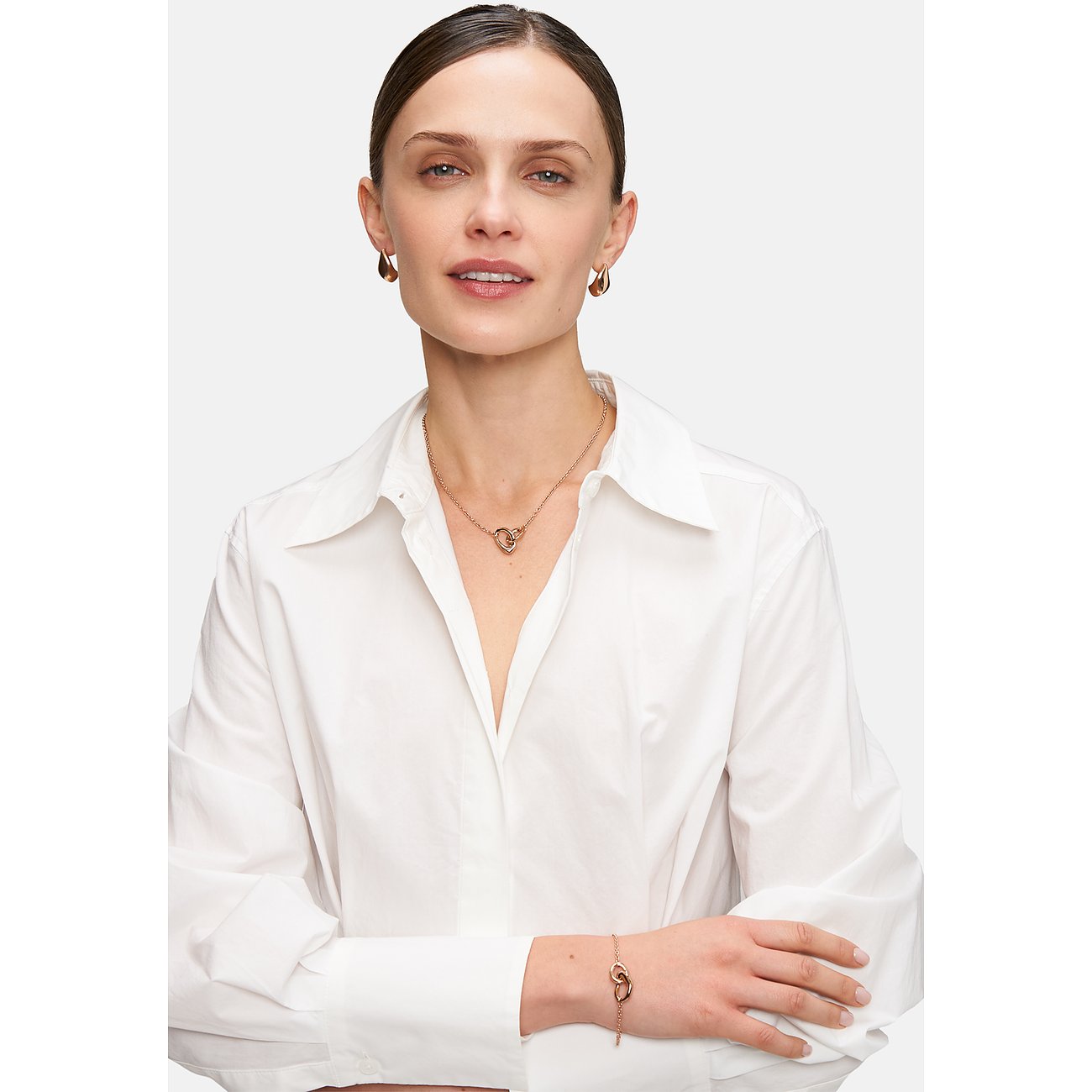 Tamaris Armband aus Edelstahl, goldfarben, mit zwei ineinandergreifenden Herzen.