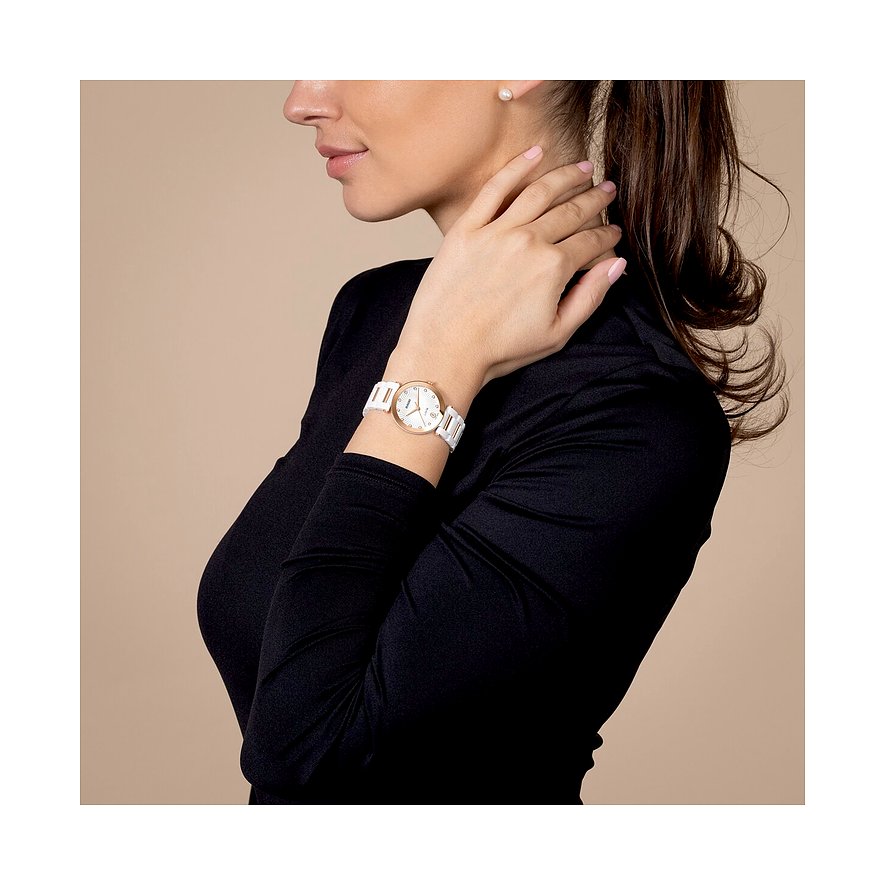 Seitenansicht einer Frau mit einer Rado Damenuhr aus weißer Keramik und diamantbesetztem Zifferblatt am Handgelenk.