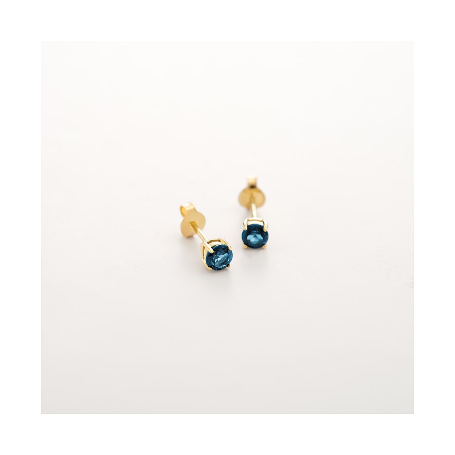 CHRIST Ohrstecker aus 375er Gelbgold mit facettierten blauen Topas-Farbsteinen auf weißem Hintergrund.