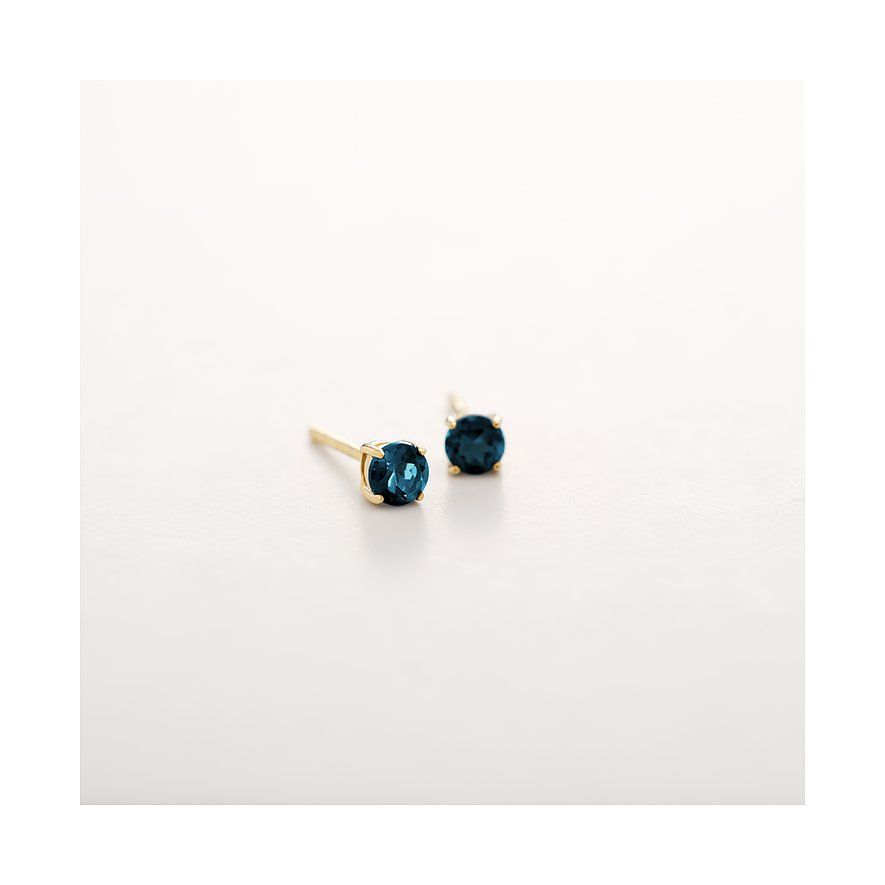 CHRIST Ohrstecker aus 375er Gelbgold mit facettiertem blauem Topas als Blickfang auf reinweißem Grund.