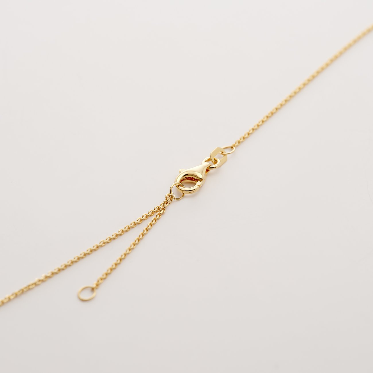 Nahaufnahme des Verschlusses einer CHRIST 585 Gelbgold Halskette, der einen Karabinerhaken und eine Verlängerungskette zeigt.