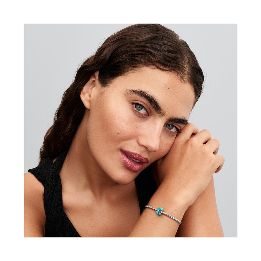 Nahaufnahme einer Frau mit einem Pandora Silber-Armband, das einen blauen Zirkonia-Farbstein-Anhänger hat.