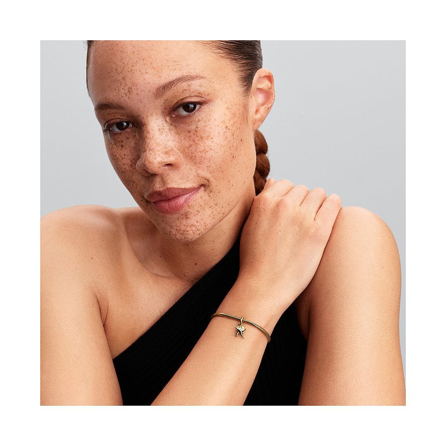 Ein Model trägt ein Pandora Metall Charm-Armband mit einem Seestern-Anhänger mit Zirkonia, der am Handgelenk baumelt.