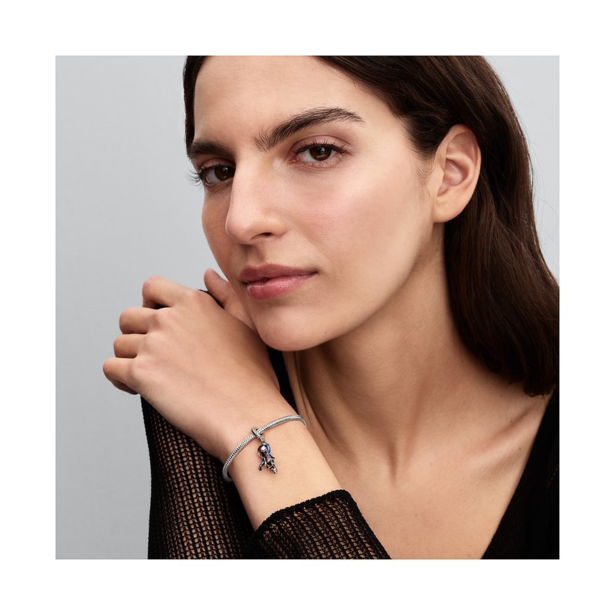 Nahaufnahme einer Frau, die ein Pandora Charm-Armband aus 925er Silber mit einem verspielten Emaille-Anhänger trägt.