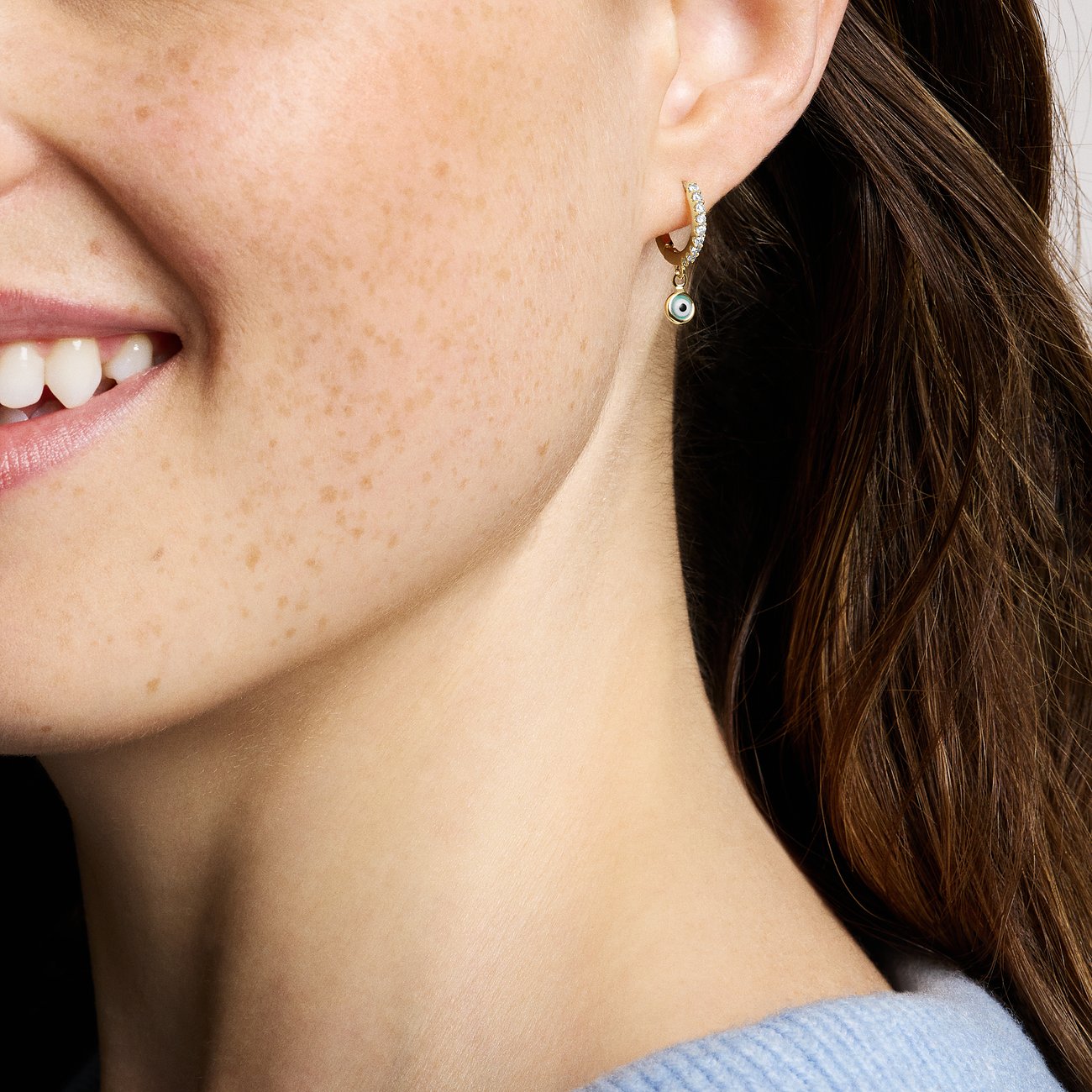 Fossil Ohrringe mit Glasstein und goldfarbenem Metall.