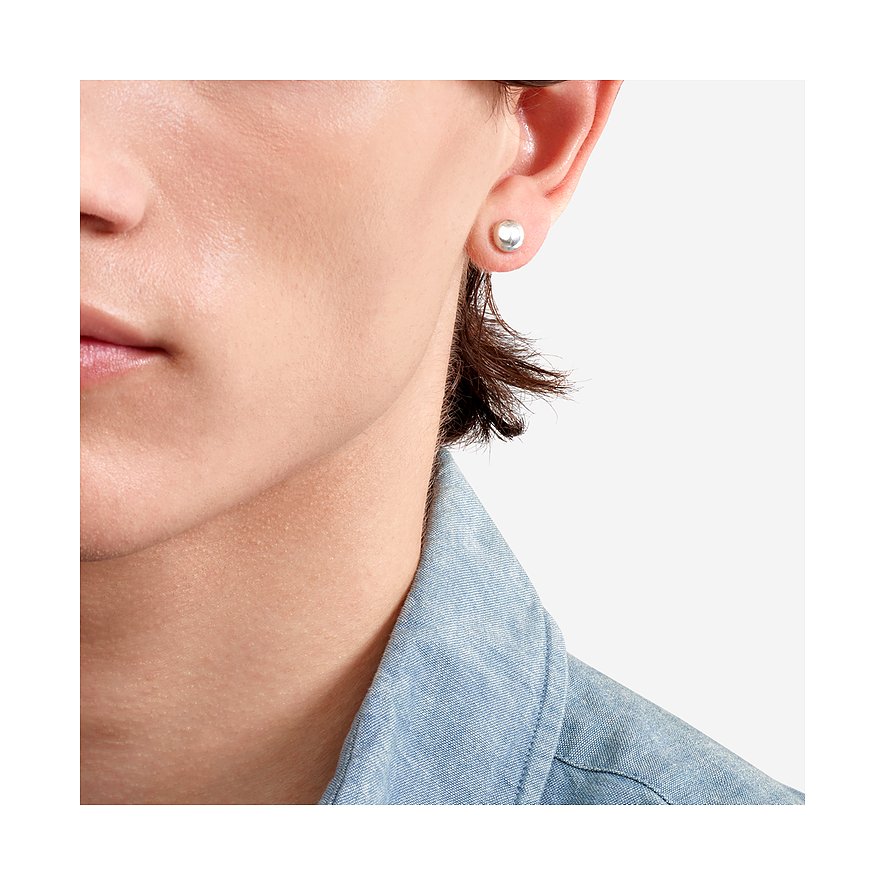 Close-up van een oor met een ronde, effen en glanzende DoDo oorknop van 925 zilver.