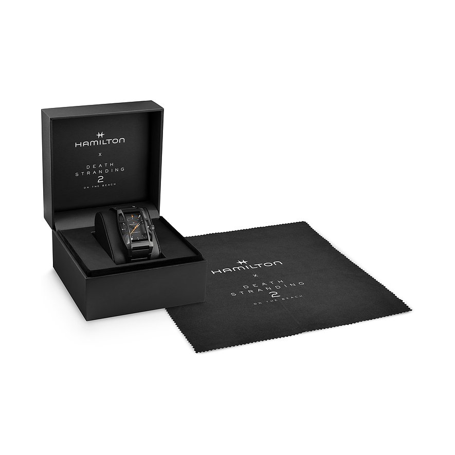 Eine Hamilton Unisexuhr aus Titan in einer schwarzen Box mit einem Mikrofasertuch daneben.