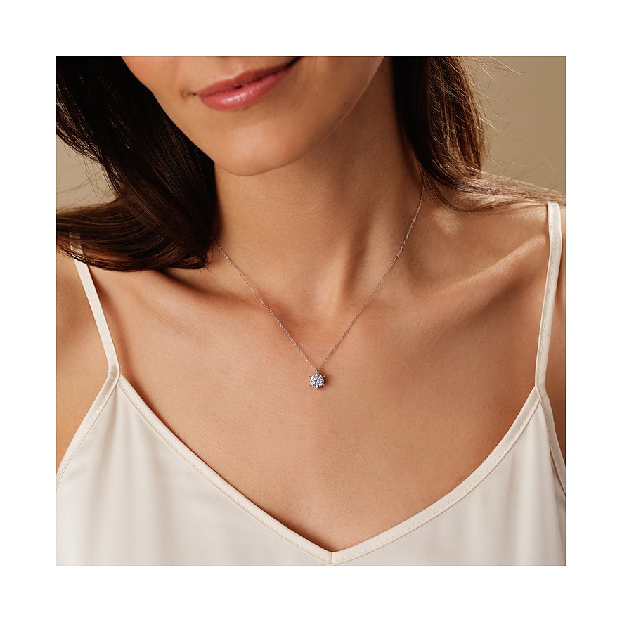 Nahaufnahme einer Frau, die eine CHRIST Halskette aus 585 Weißgold trägt, mit einem funkelnden Diamanten als Anhänger.