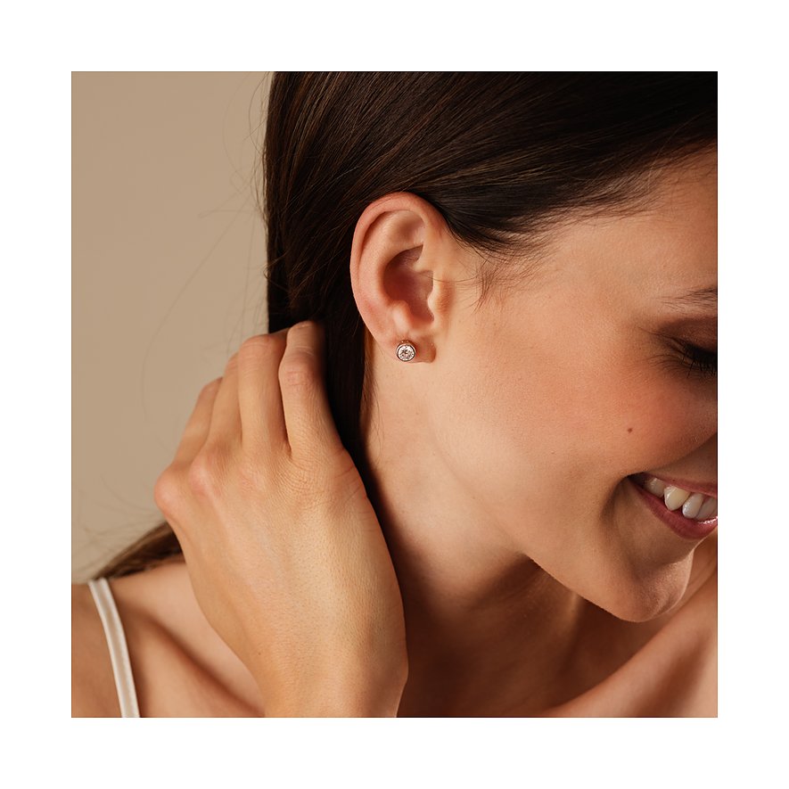 Ein CHRIST Weißgold-Ohrstecker mit Diamant ist am Ohr einer Frau zu sehen, ihr Haar ist dunkel und zurückgestrichen.