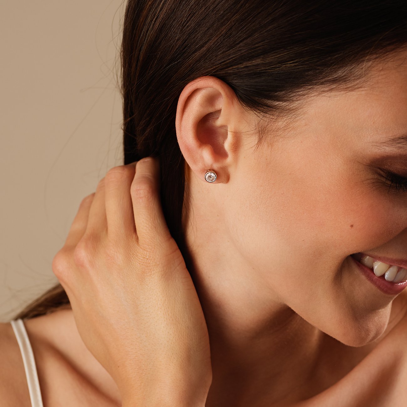 Ein CHRIST Weißgold-Ohrstecker mit Diamant ist am Ohr einer Frau zu sehen, ihr Haar ist dunkel und zurückgestrichen.