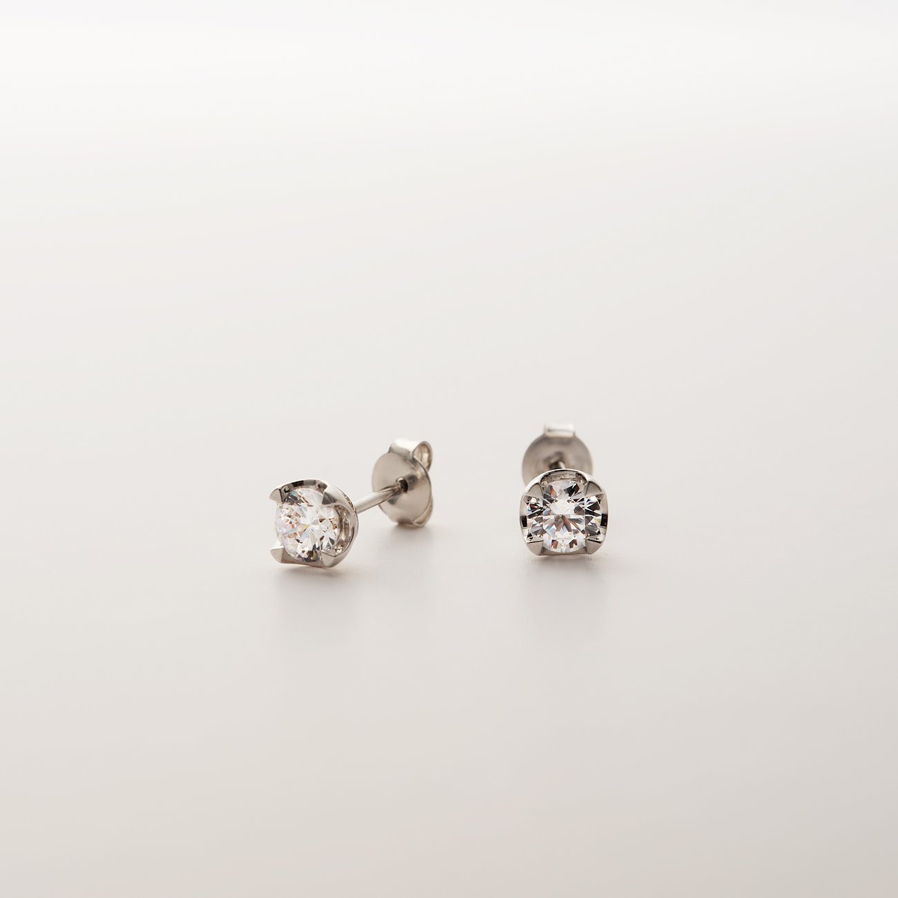 CHRIST Ohrstecker aus 585 Weißgold mit funkelnden Diamanten, im Vordergrund ein Ohrstecker seitlich.