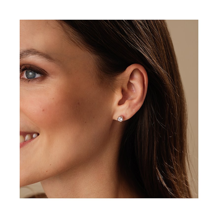 Nahaufnahme einer Frau von der Seite, die einen CHRIST 585 Weißgold Ohrstecker mit Diamanten trägt.