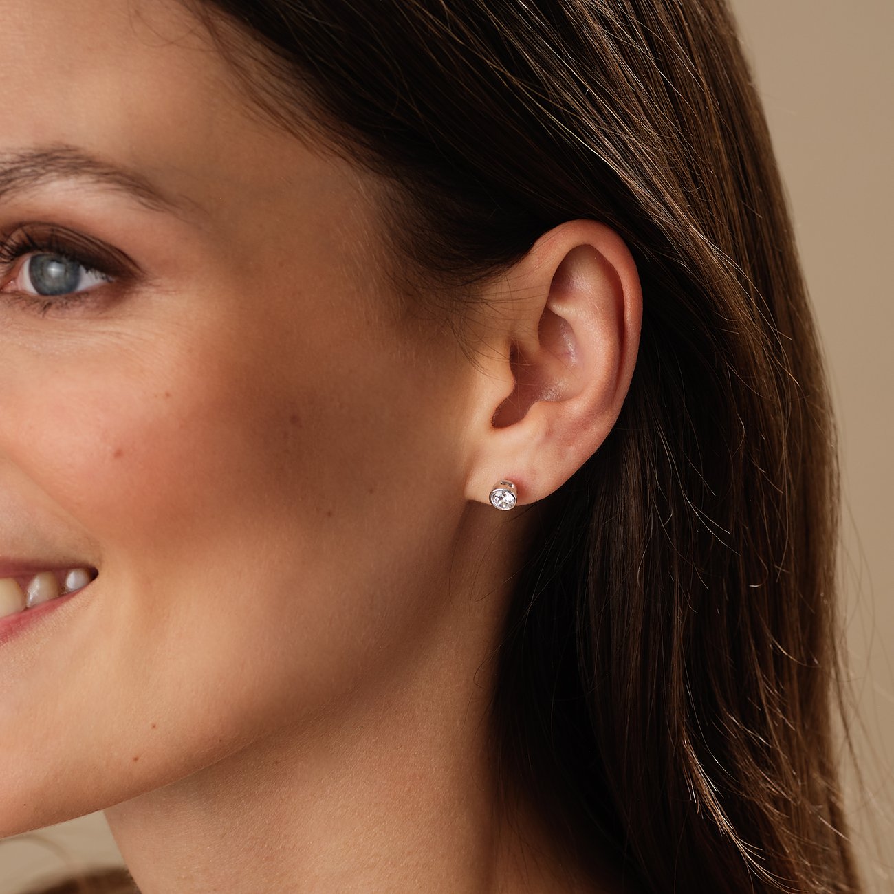 Nahaufnahme einer Frau von der Seite, die einen CHRIST 585 Weißgold Ohrstecker mit Diamanten trägt.