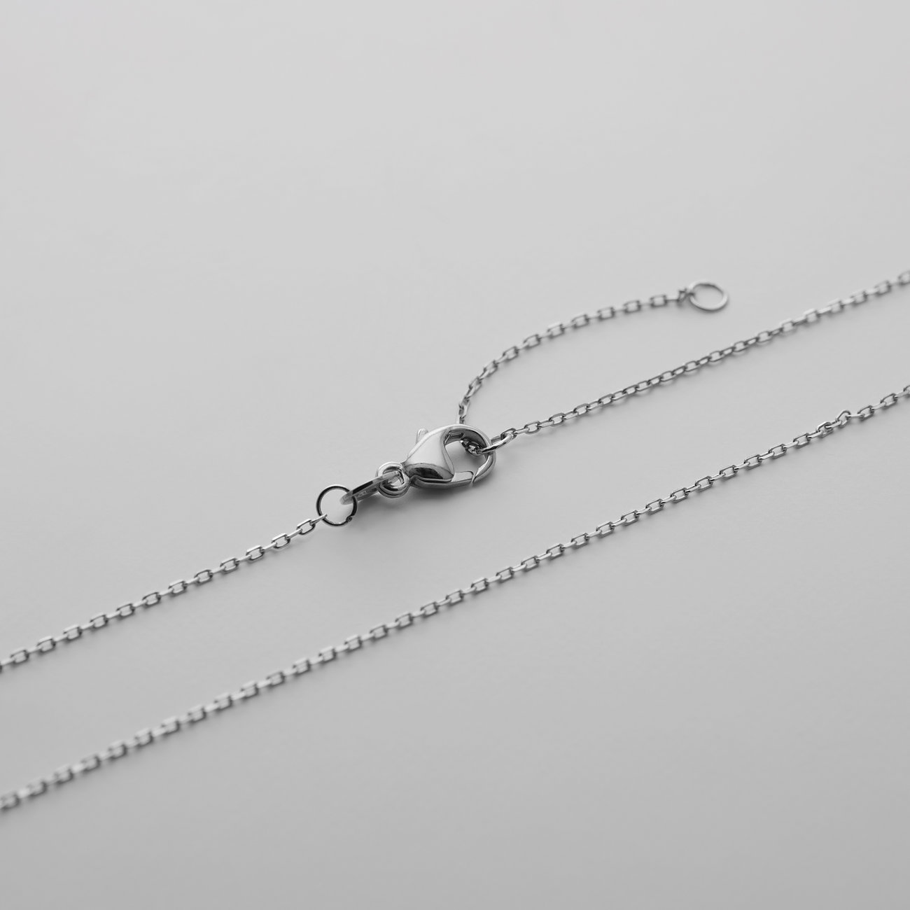 Detailaufnahme des Verschlusses einer CHRIST Weißgoldkette mit Karabinerhaken und Verlängerungskette.