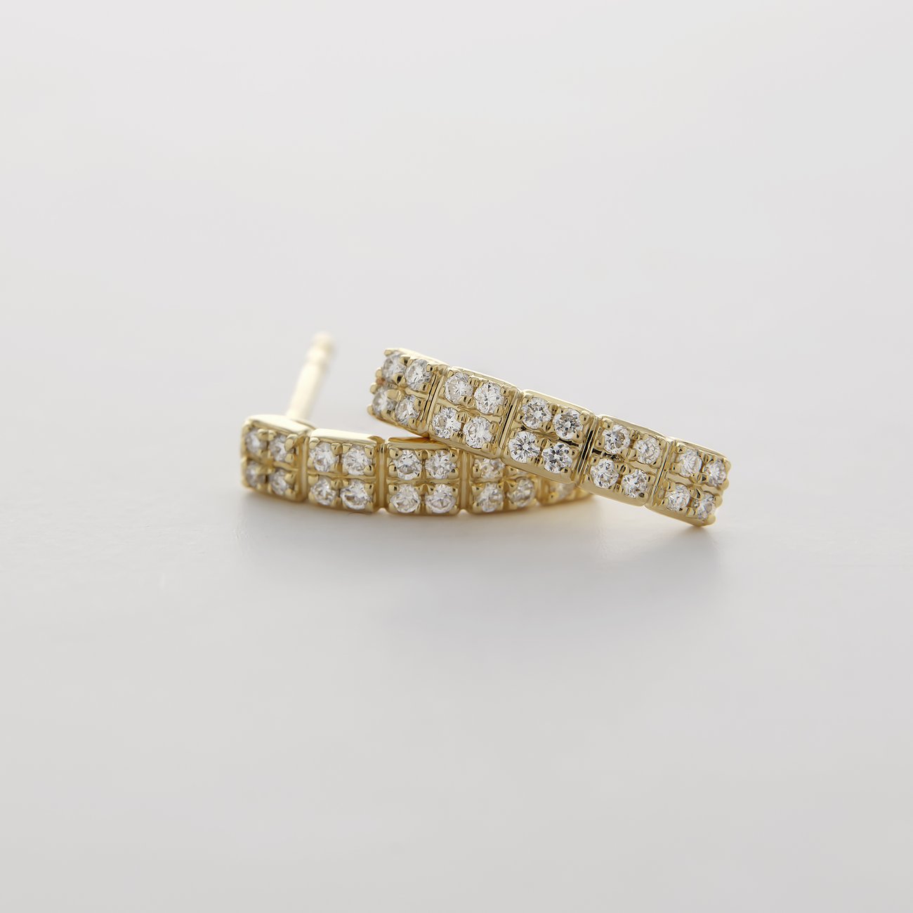 CHRIST Ohrstecker aus Gelbgold mit funkelnden Diamanten, der eine halbrunde Form zeigt.