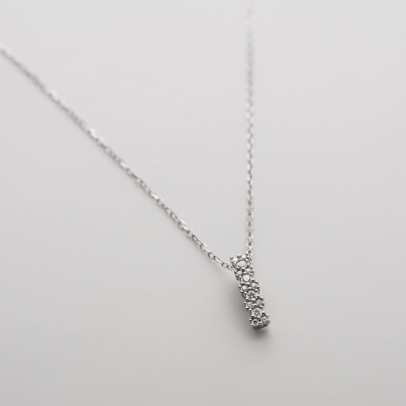 CHRIST Halsschmuck aus 585er Weißgold mit einem vertikalen Anhänger, besetzt mit mehreren Diamanten.