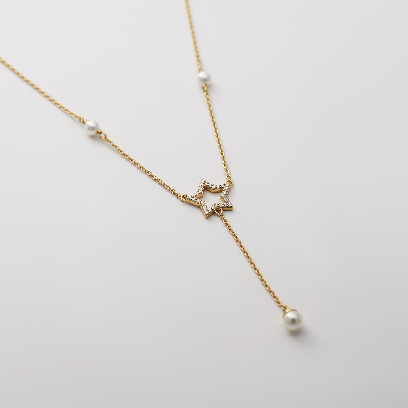 CHRIST Halsschmuck aus goldfarbenem recyceltem Silber mit Zirkonia-Stern-Anhänger und Perlen.
