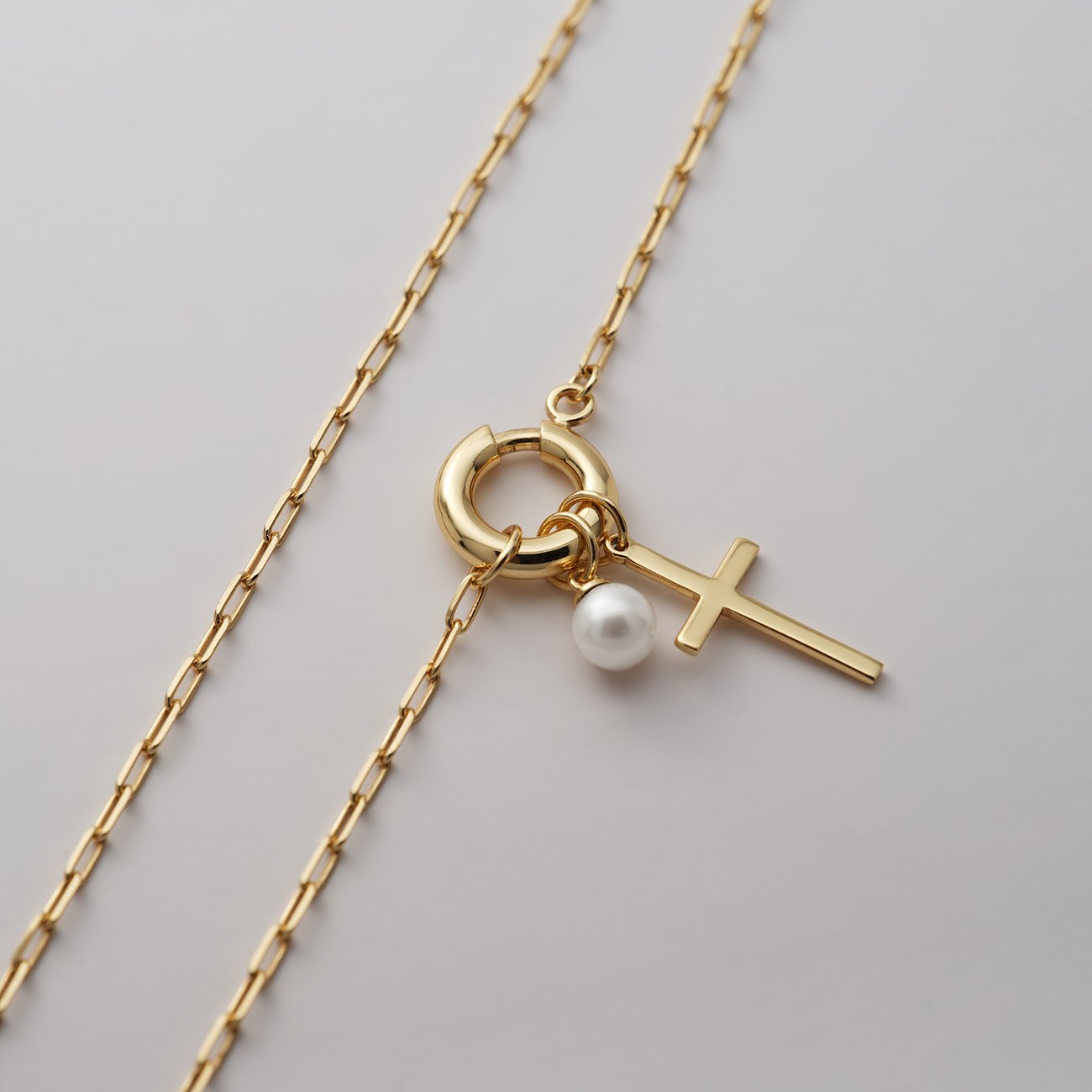 CHRIST ketting van gerecycled goudkleurig zilver met togglesluiting, parel en klein kruisje.