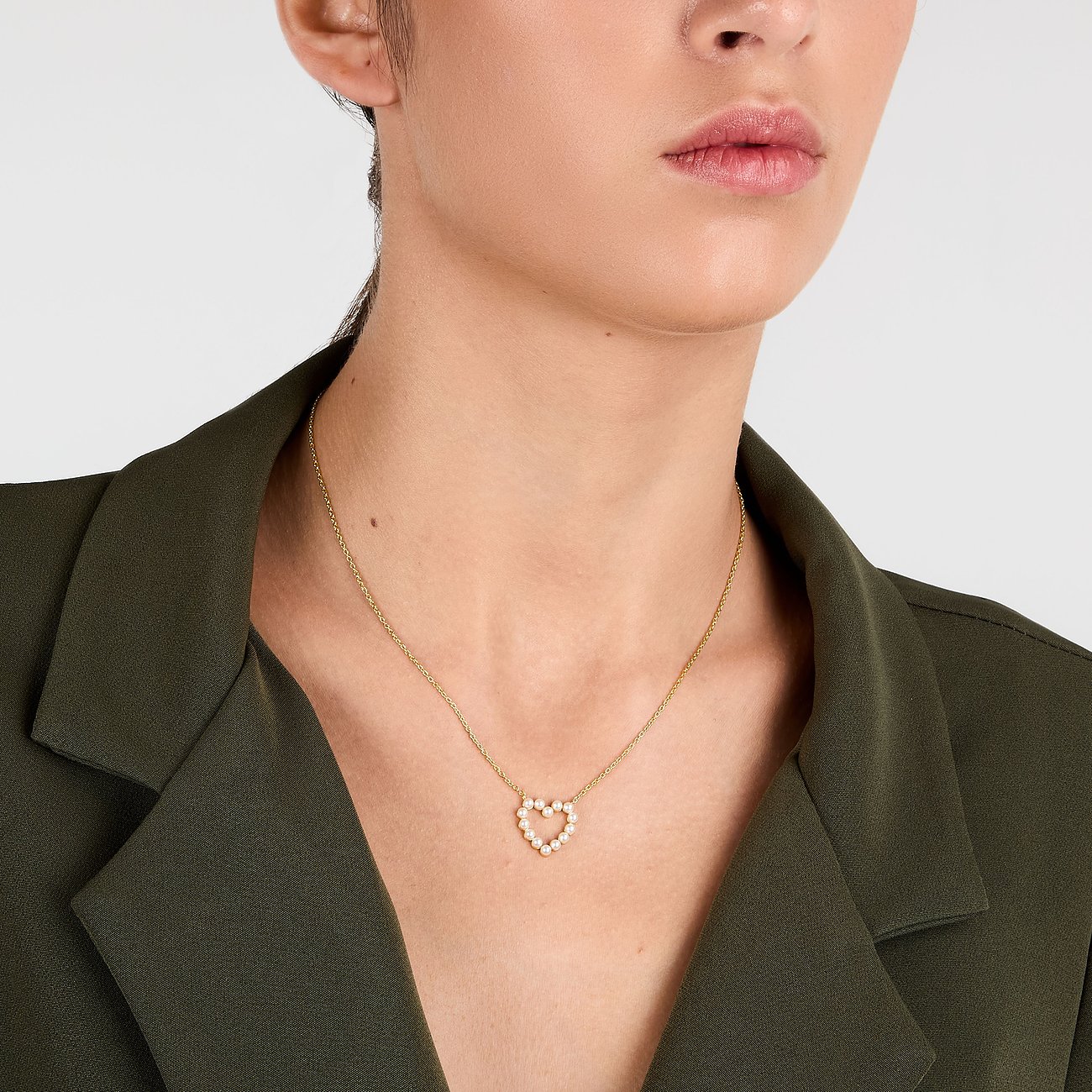 Primo piano di una donna che indossa una collana La Petite Story color argento con ciondolo a cuore.