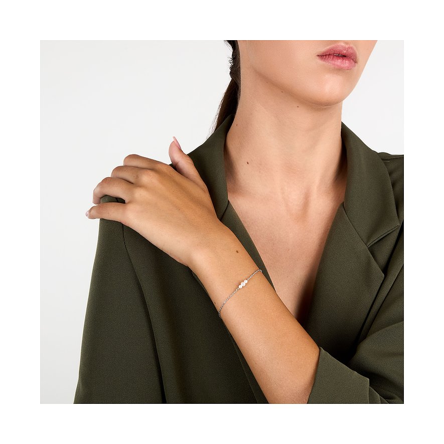 Am Handgelenk einer Frau getragenes La Petite Story Armband aus rhodiniertem Silber mit drei weißen Perlen.