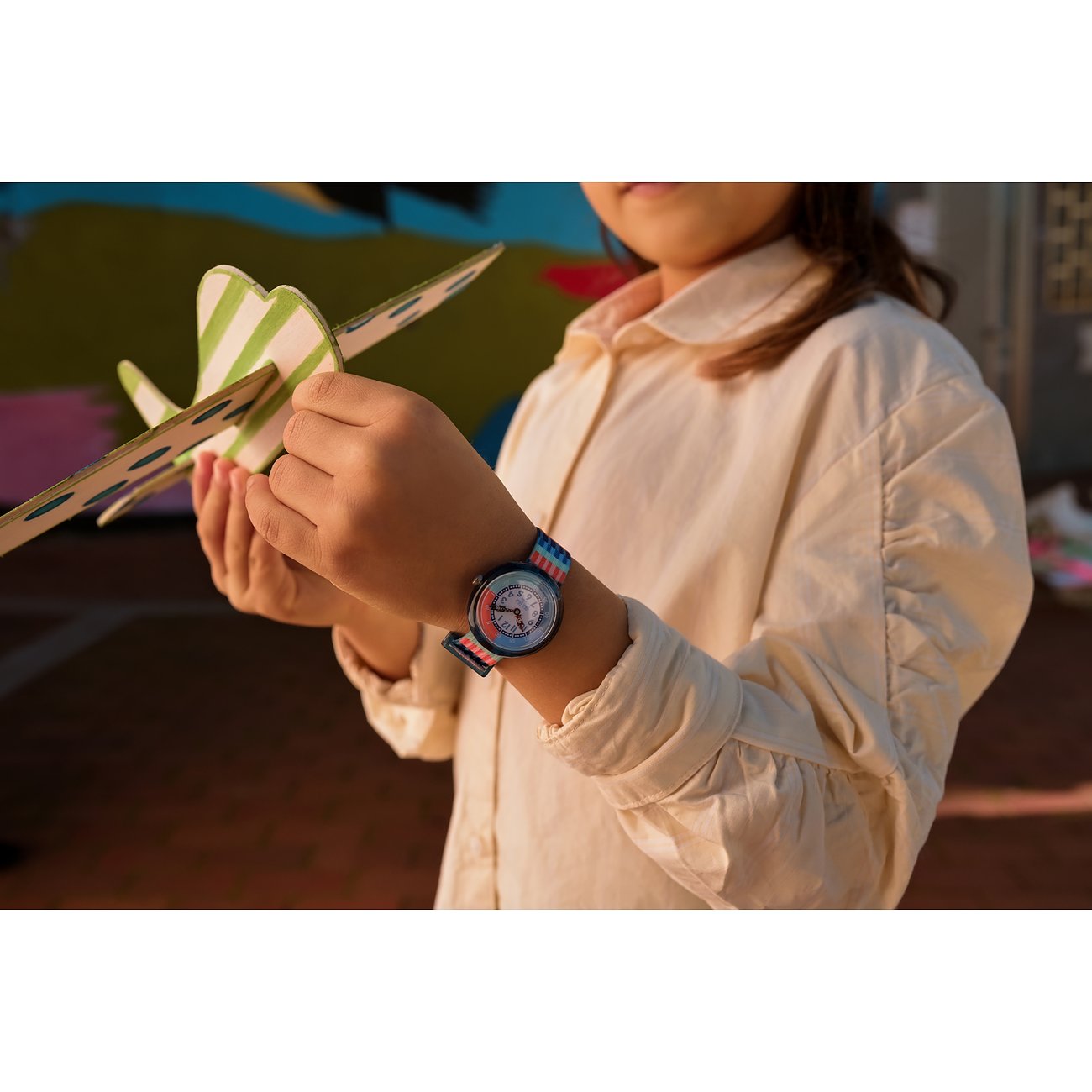 Flik Flak Kinderuhr mit Kunststoffgehäuse, bunt gestreiftem Armband und analoger Anzeige.