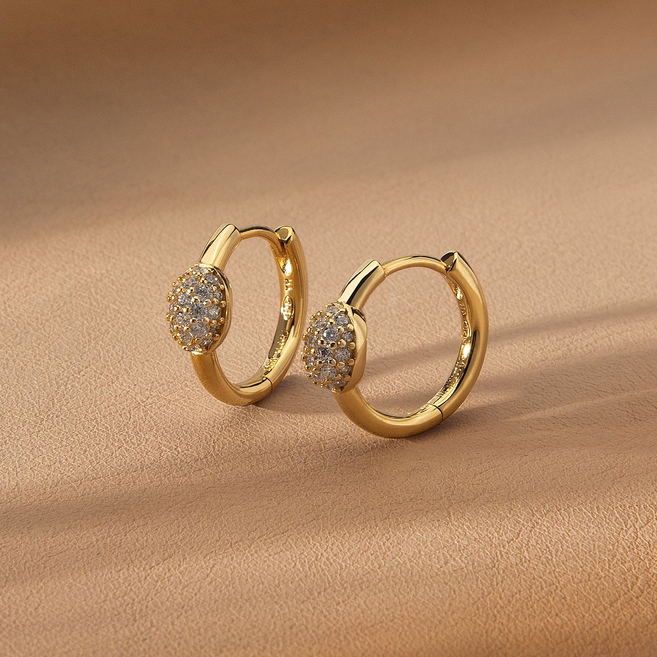 Två gyllene Morellato kreolörhängen i återvunnet silver med en rad gnistrande zirkoniastenar.